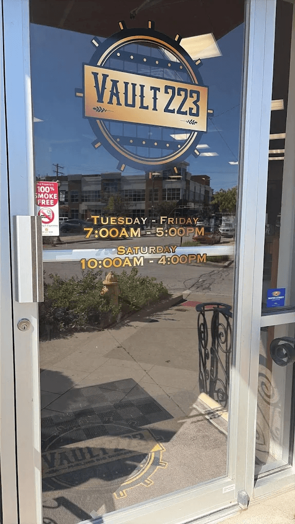 The Vault 223 entrance door with logo and hours